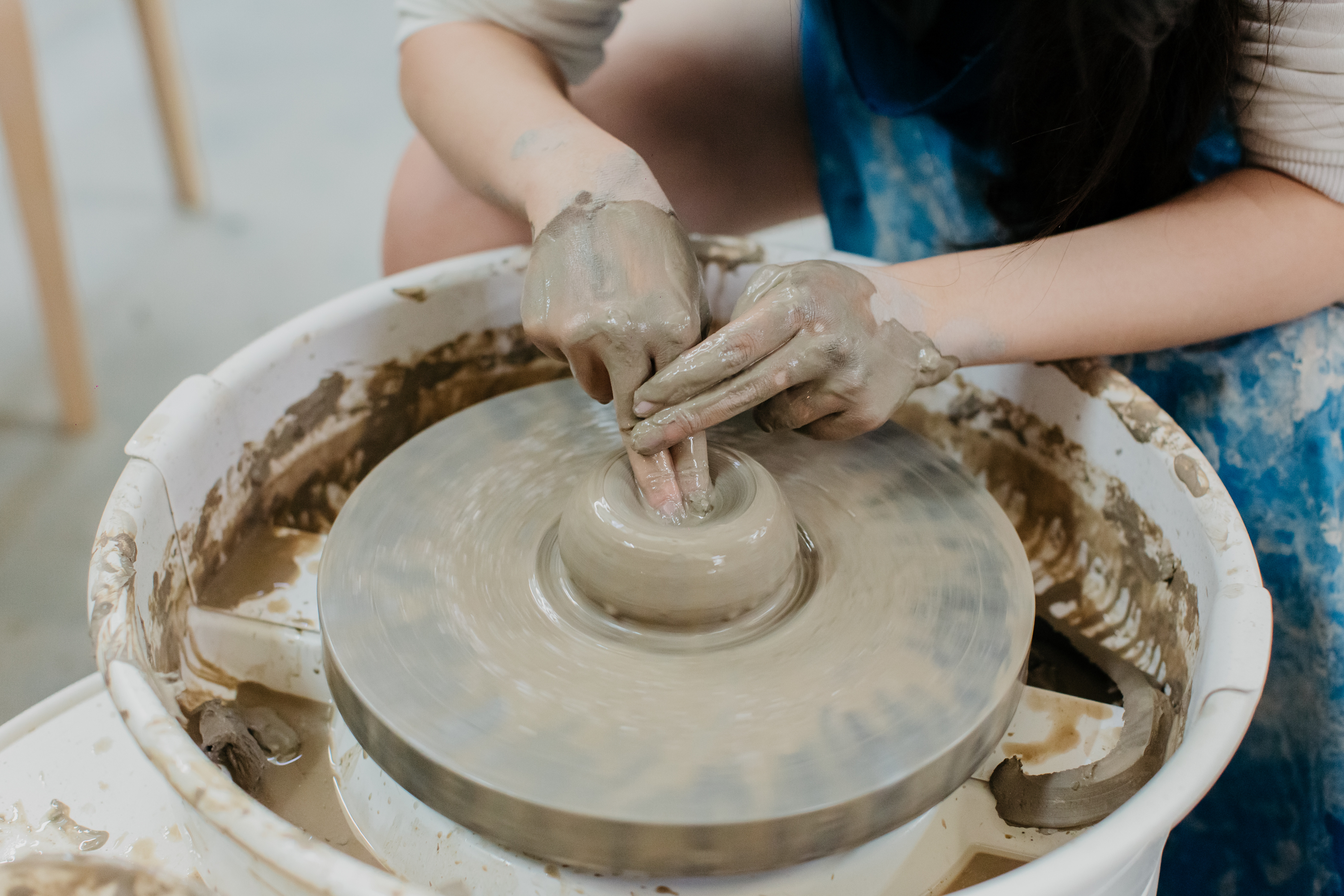 Person preparing a potter's wheel for use