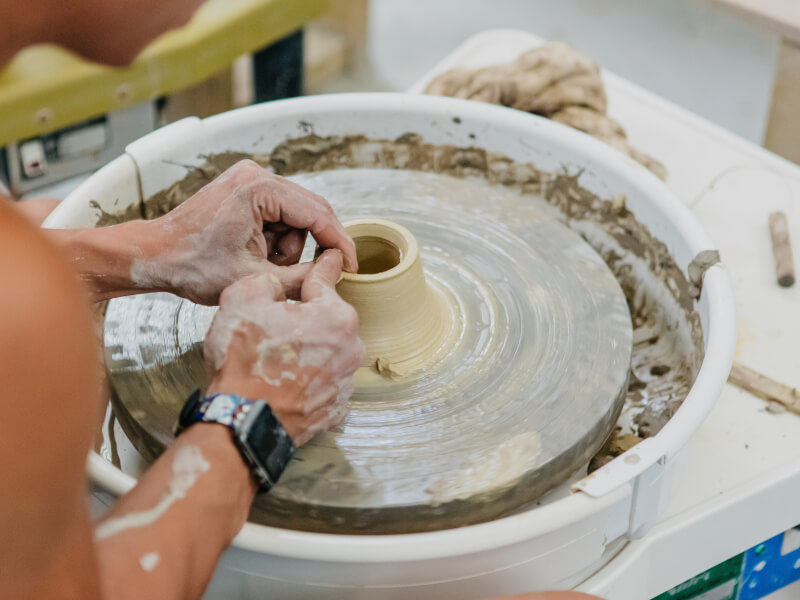 Person shaping clay on a potter's wheel