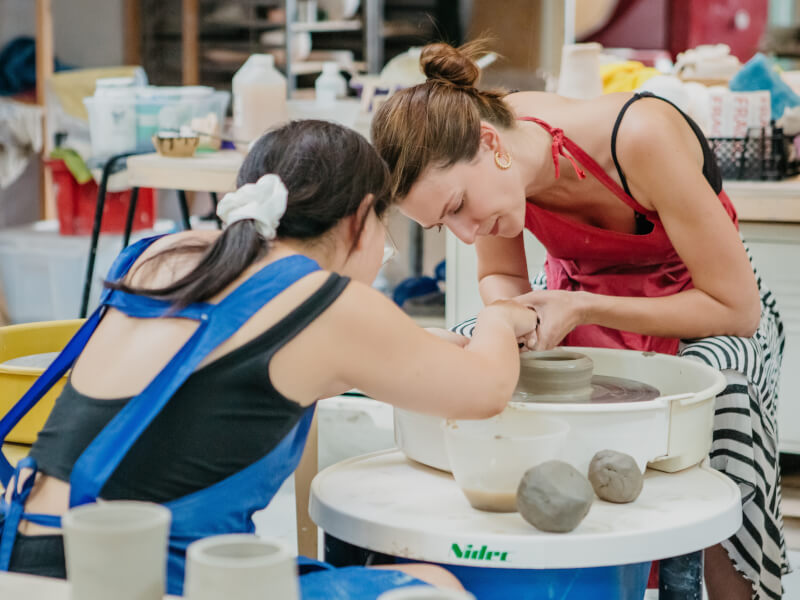 Two women working at a potter's wheel