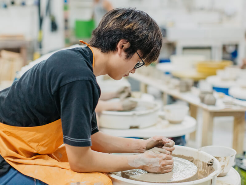 A man making handmade pottery on a wheel.