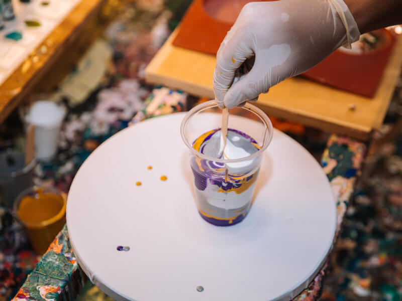 A plastic cup of paint at a fluid art class.