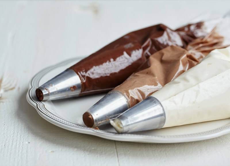 Piping bags of white, dark and milk chocolate.