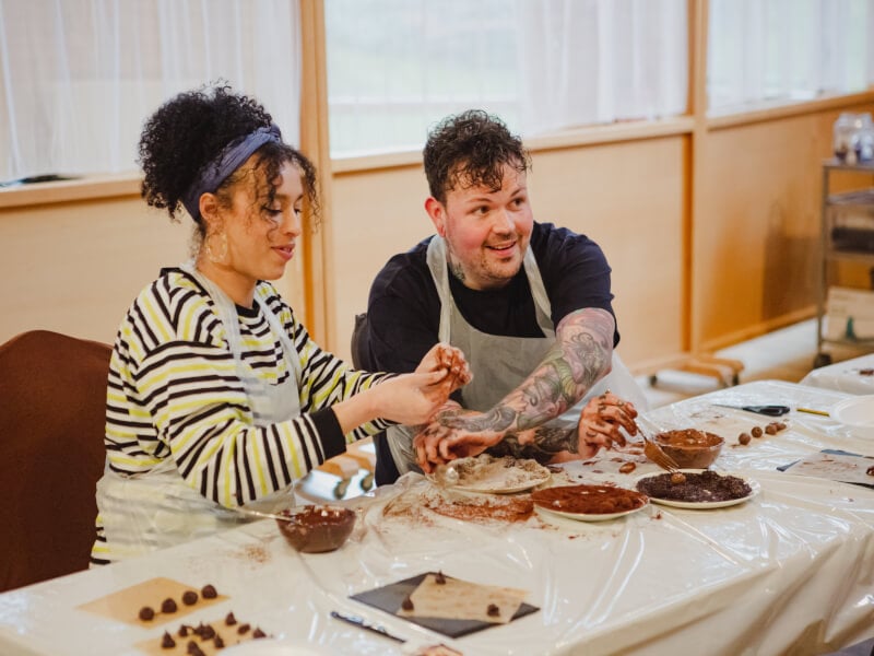 A couple making truffles in a chocolate making class 