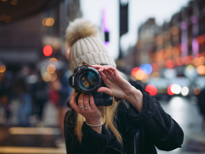 A shot of a woman holding her camera to her face in a photography class.