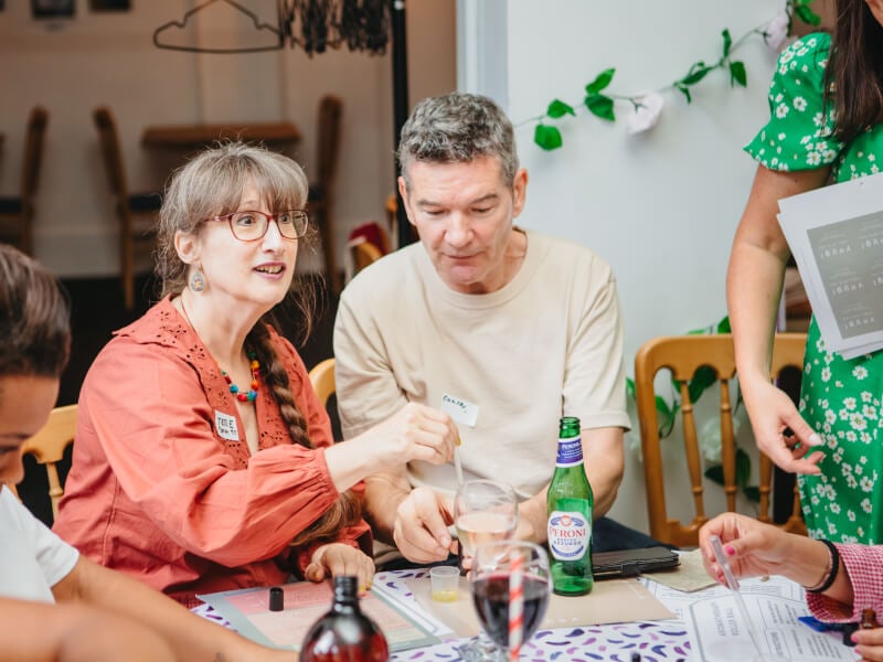 A couple sit with others at a perfume blending experience