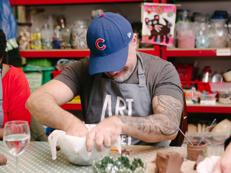 A man working at a hand building pottery class