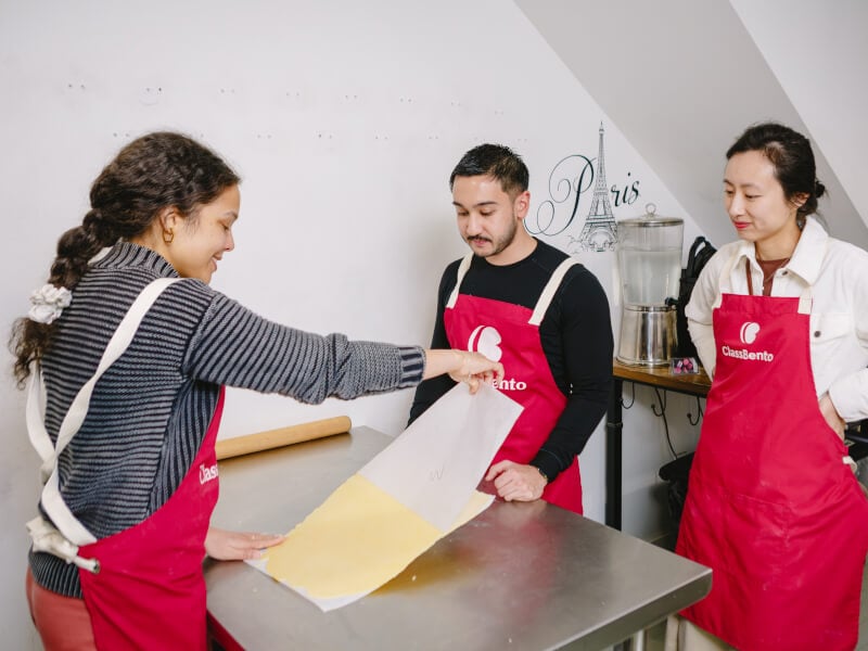 A teacher and students work together at a baking class