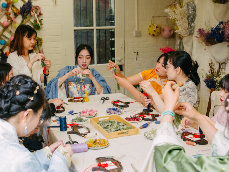 A group of women in East Asian dress at a flower arranging class