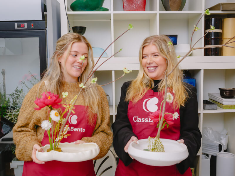Two students showing off their ikebana arrangements
