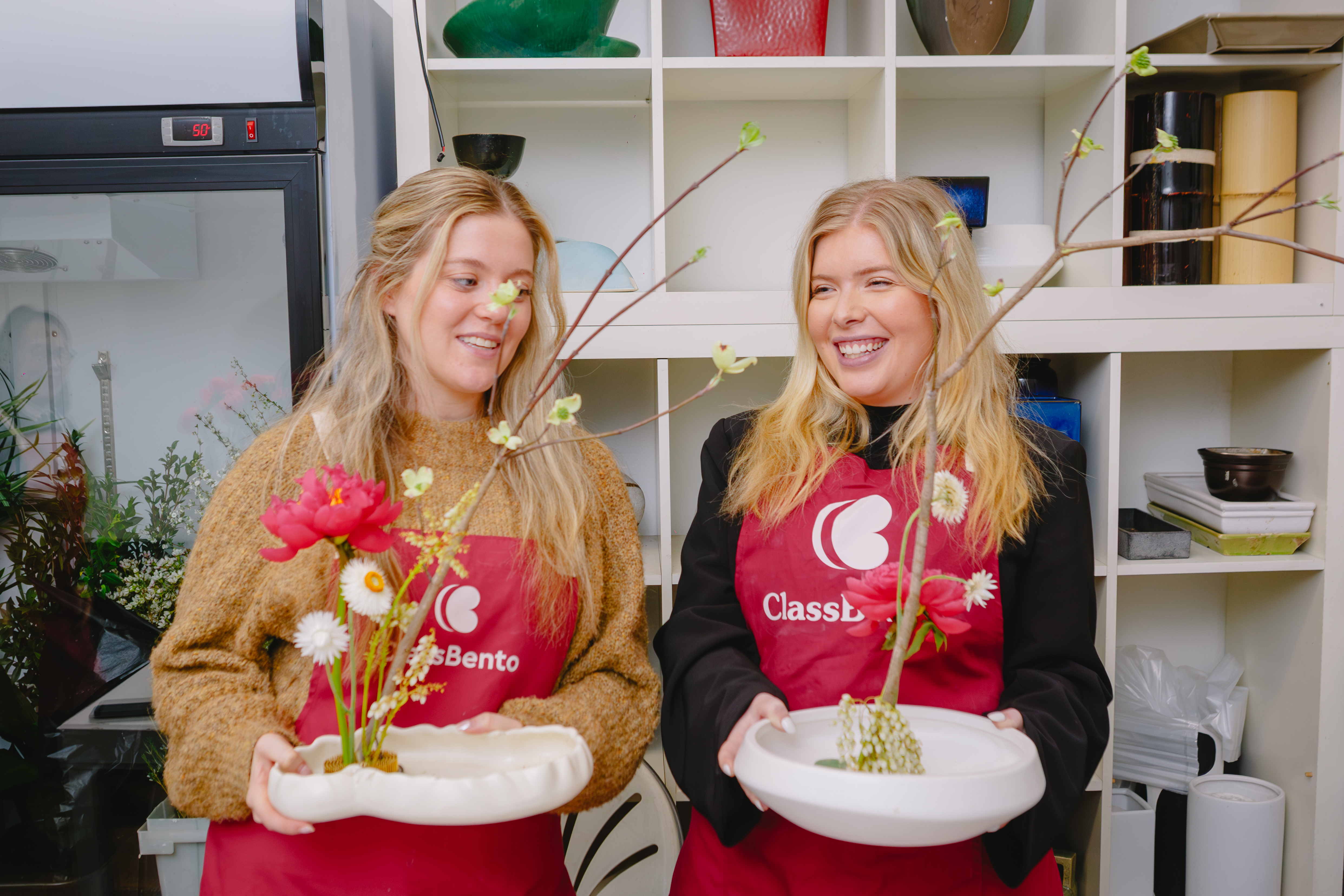 Two students showing off their ikebana arrangements