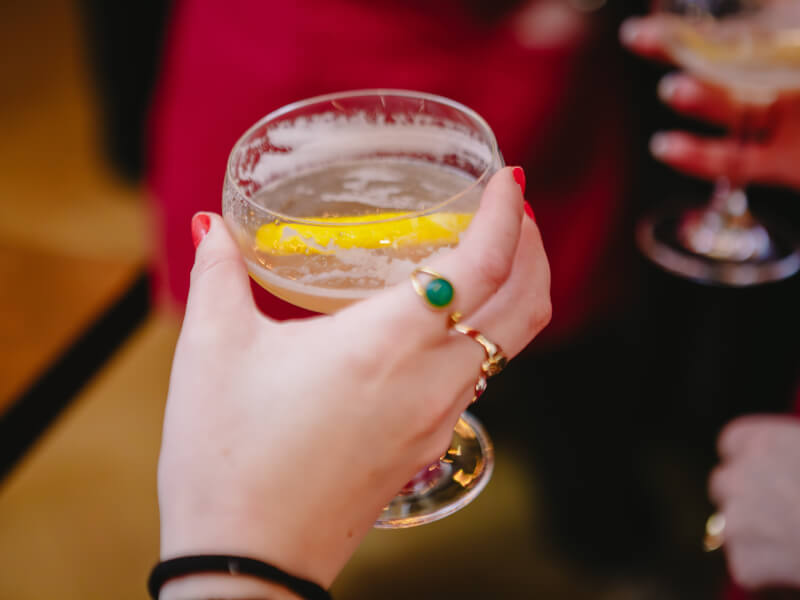 Close up of a hand holding a finished cocktail