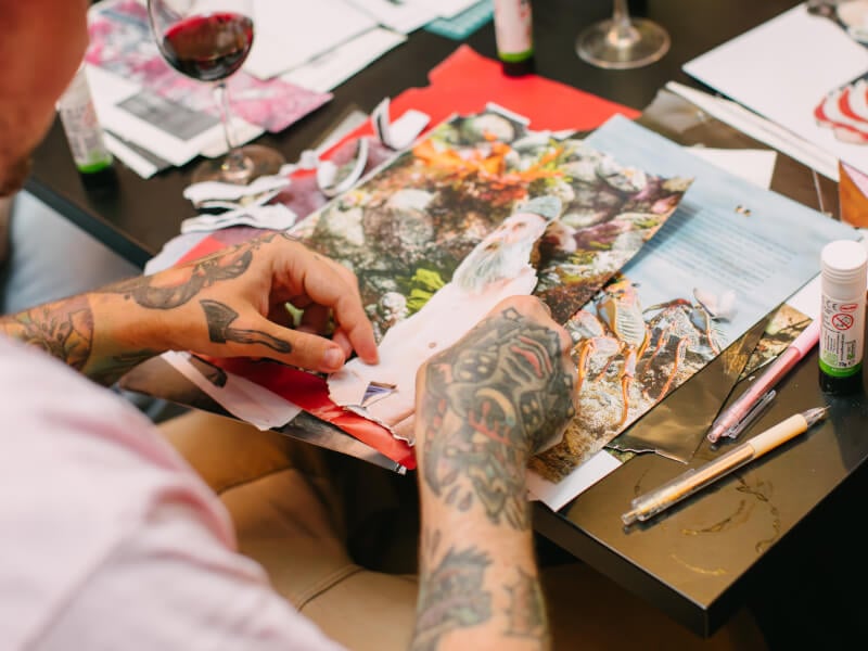 Close up of a man with tattoos making a collage