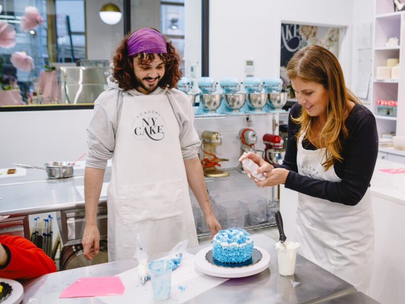 Two students working side by side at a baking class