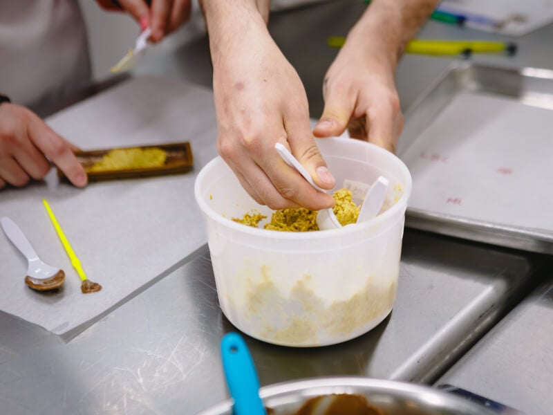 Close up of a person mixing baking ingredients in a plastic container