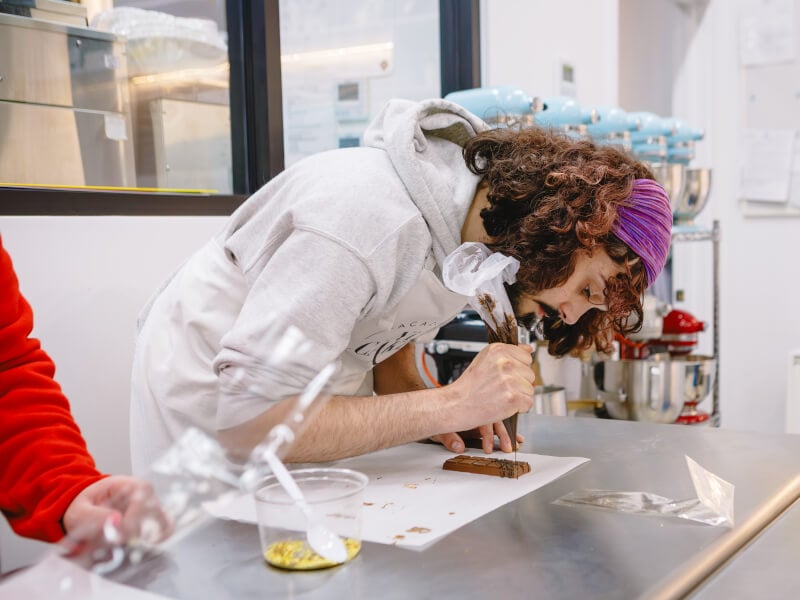 A man decorating a Dubai chocolate bar at a chocolate class