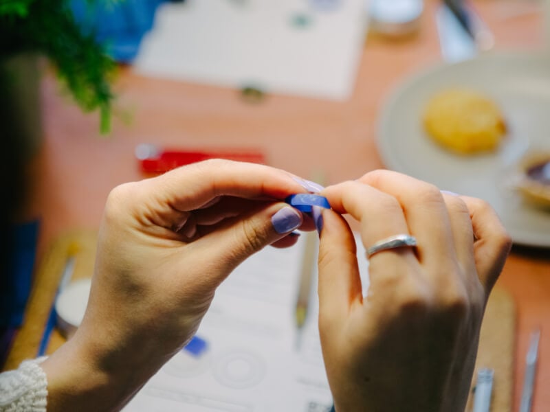 A close up of a person holding a blue wax mould used in jewellery making
