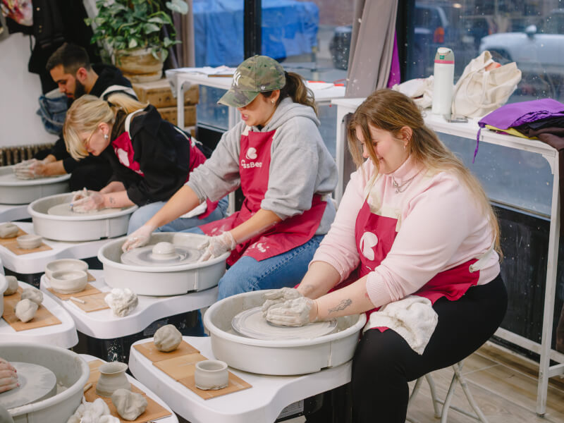 A group of people working at potter's wheels