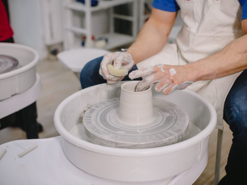 Close up of a person throwing pottery on the wheel