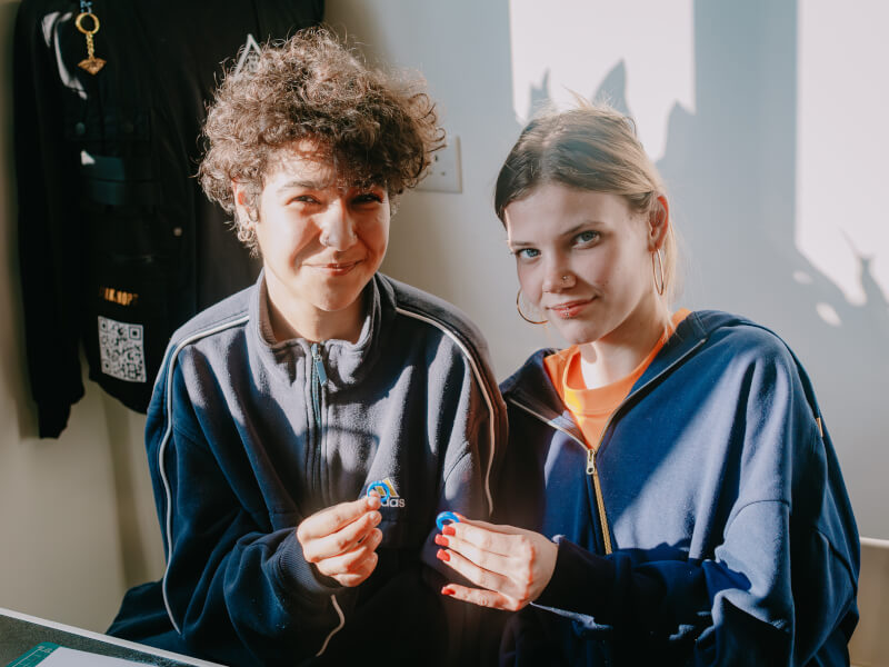Two workshop participants are smiling and holding their freshly carved blue wax ring moulds