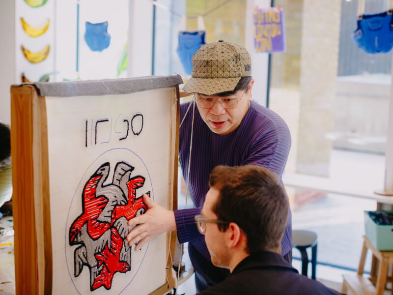 Founder of Tufting London, Chun, gives a student advice at the canvas
