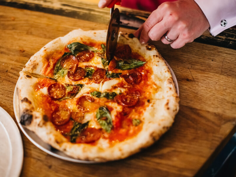 A DIY pizza being sliced up.