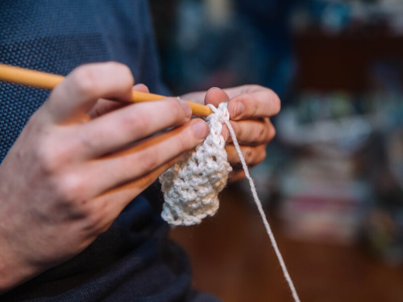 A close up of person's hands starting on a crochet project.