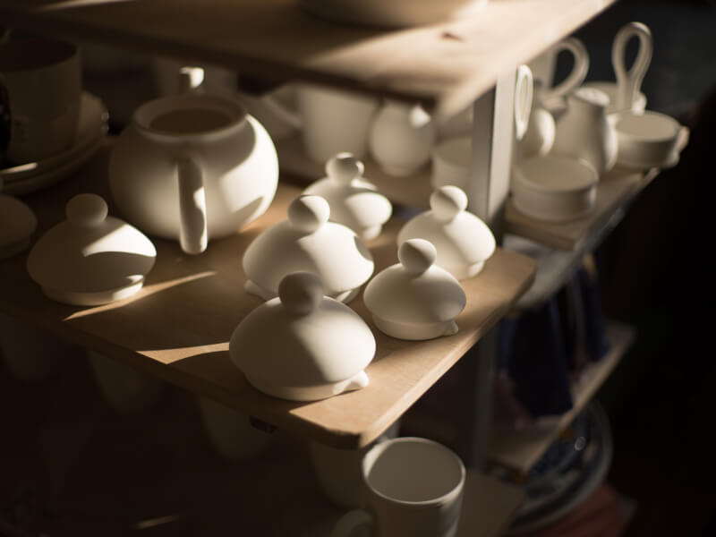 Several teapots and teapot lids placed on a shelf