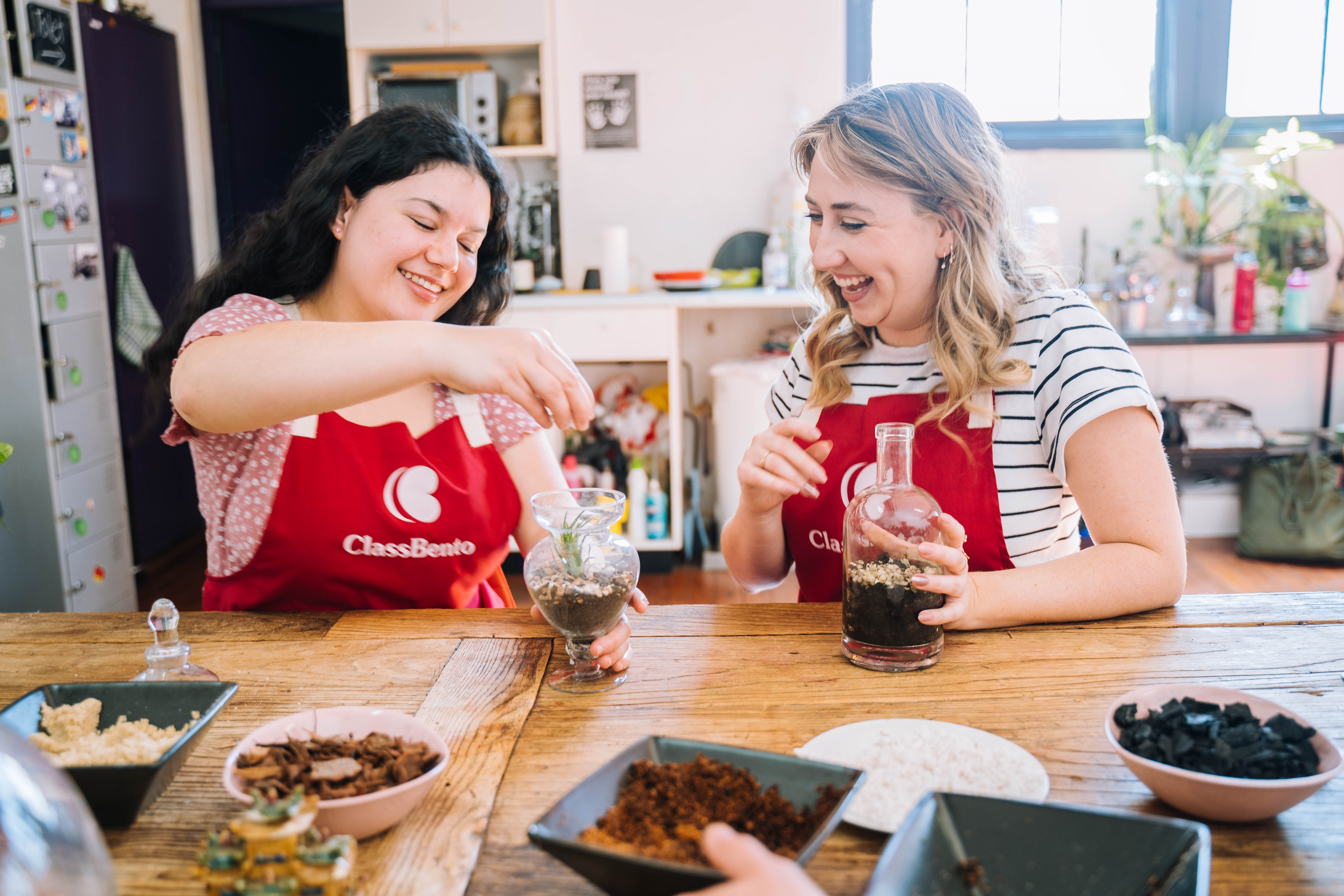 Two women enjoy making a terrarium.