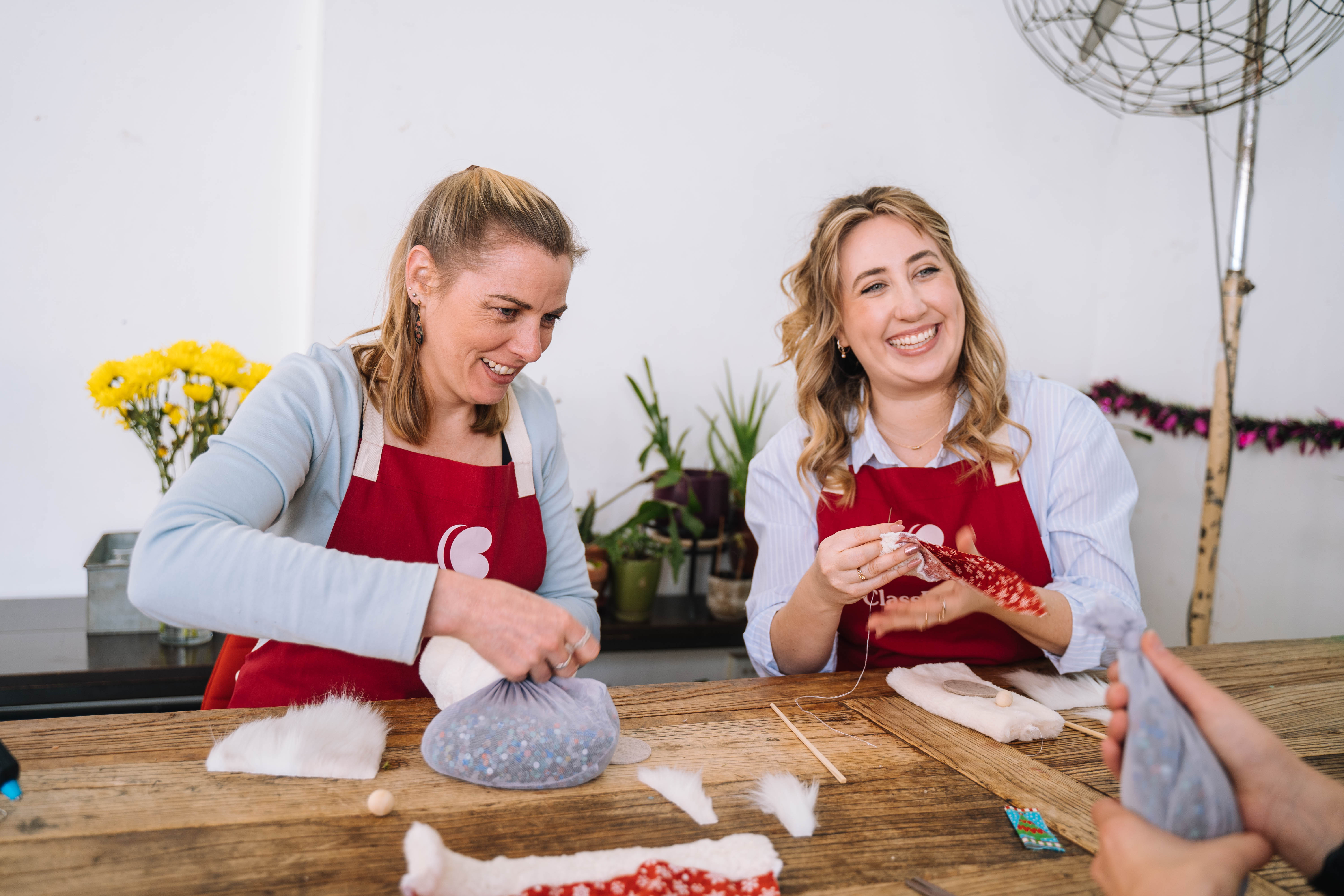 Two women smilling as they work on a craft project together