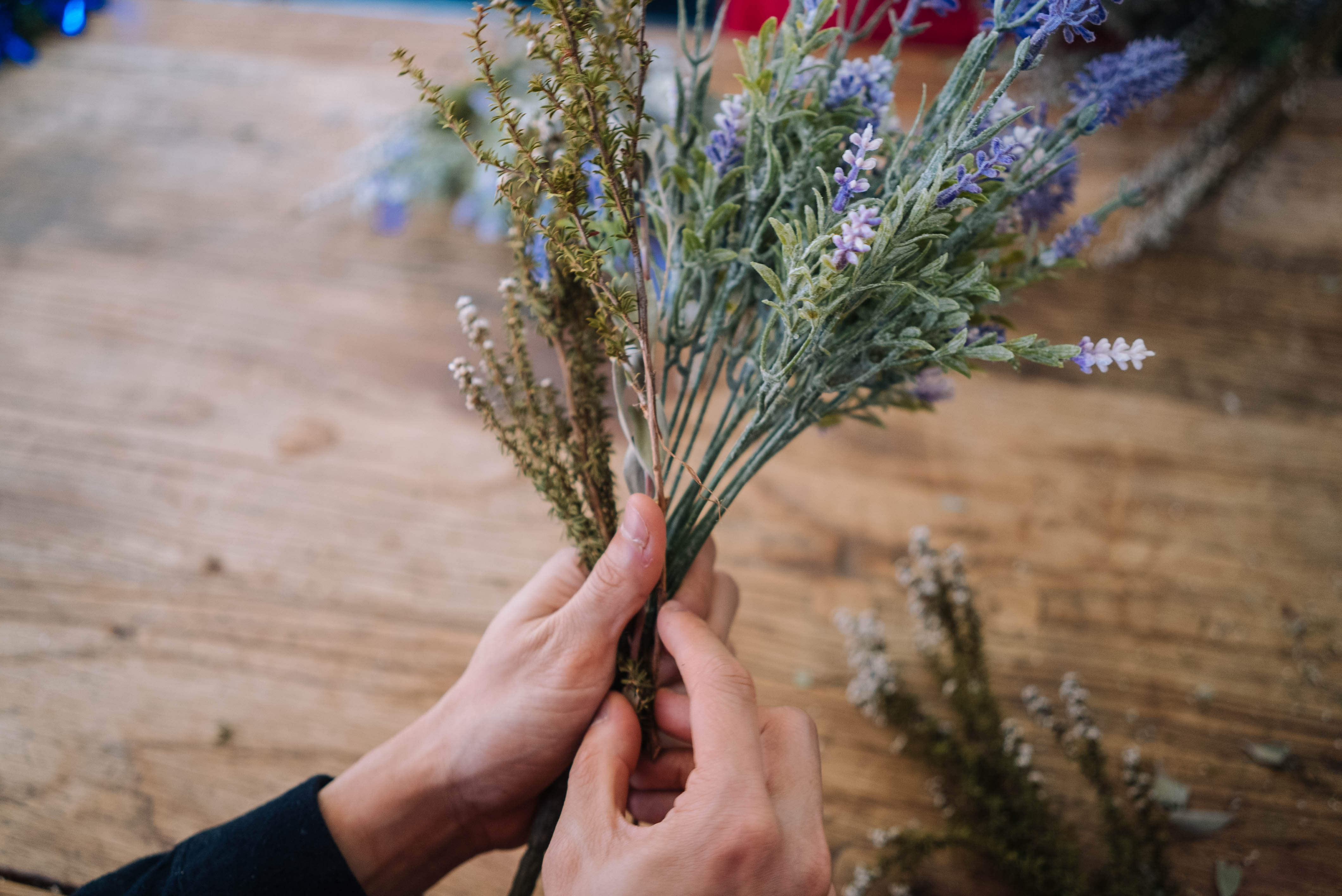 A close up of a person holding a bunch of dried flowers