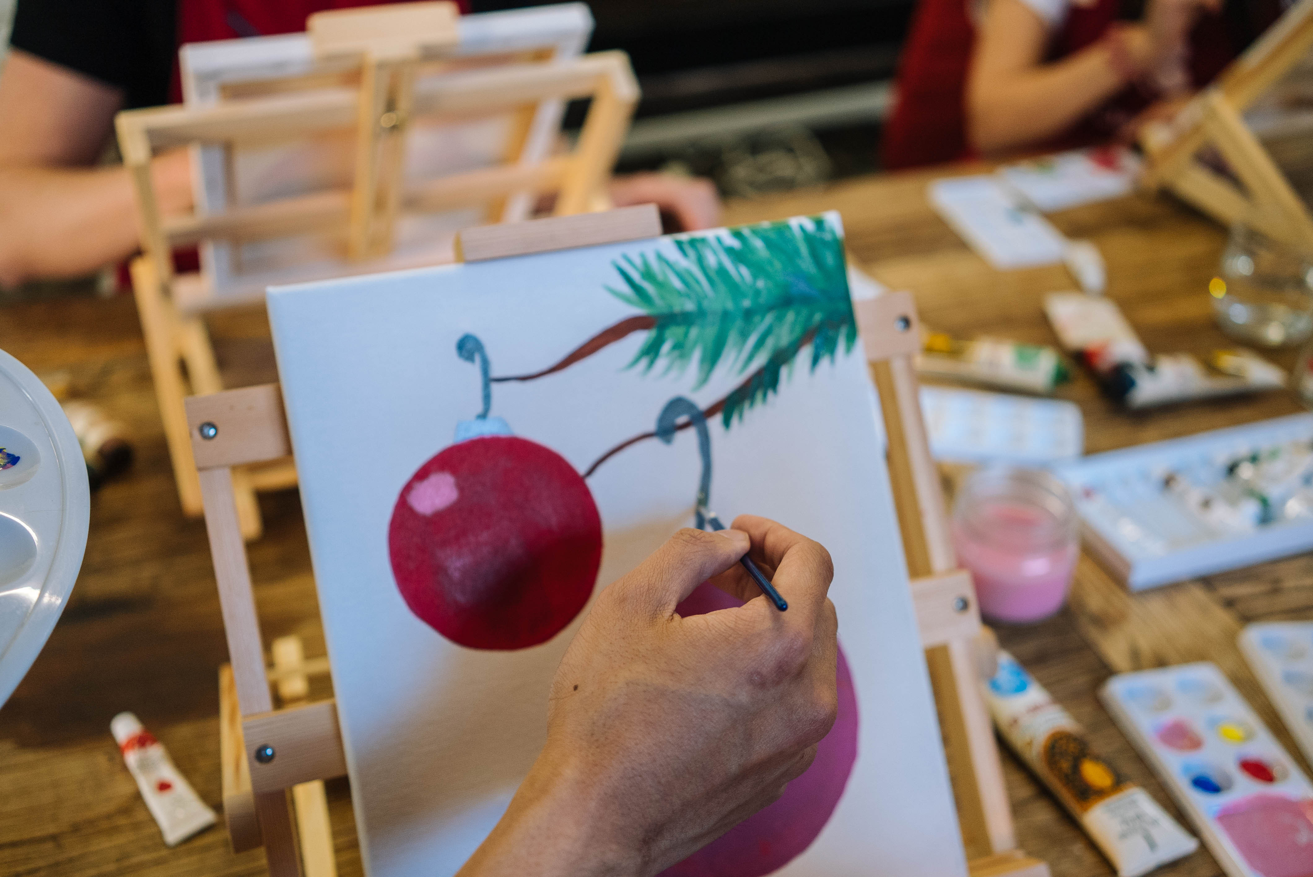 Close up of a person painting a festive picture on canvas