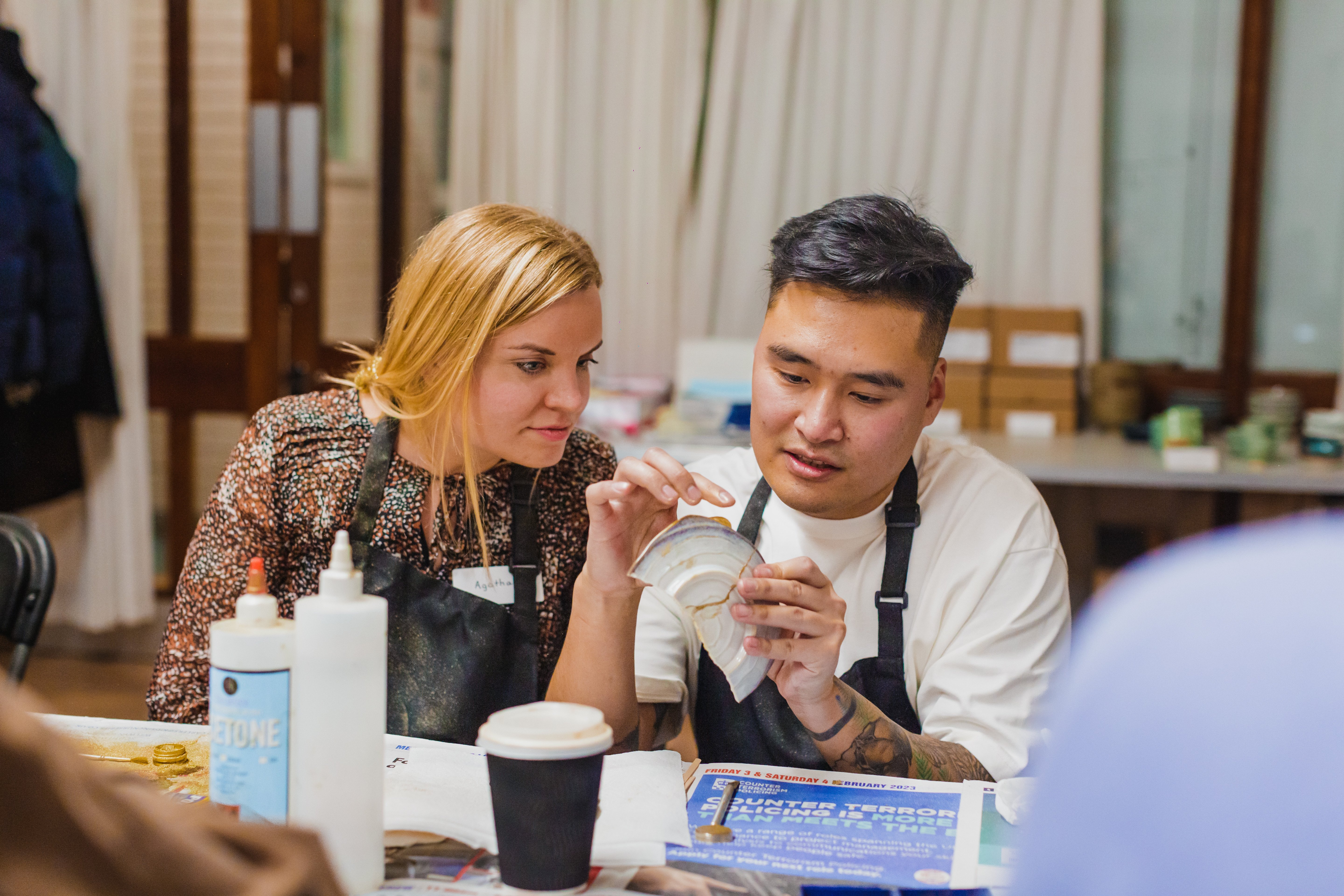 Two people learn kintsugi in a class.