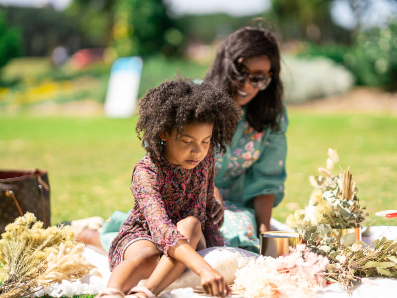 A mother and her young daughter enjoy a flower arranging class outside