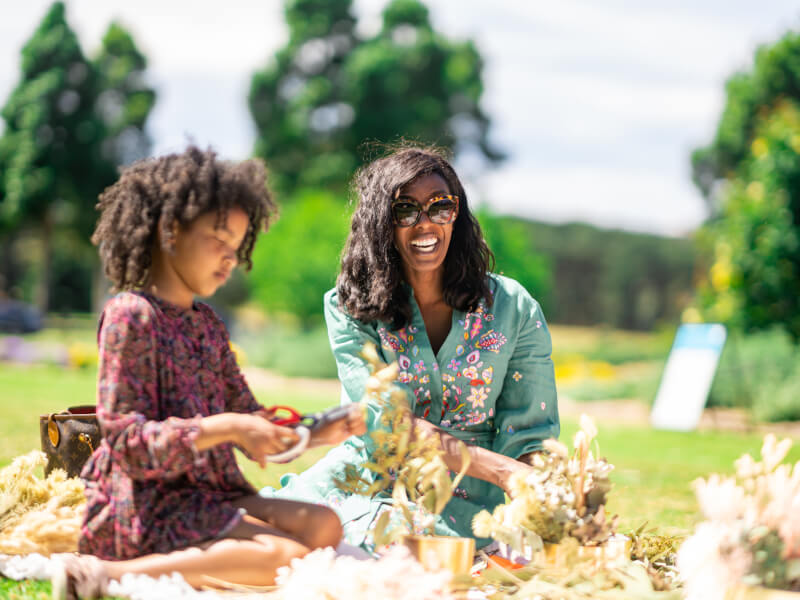 A mother and her daughter enjoying dried flower arrangement outside