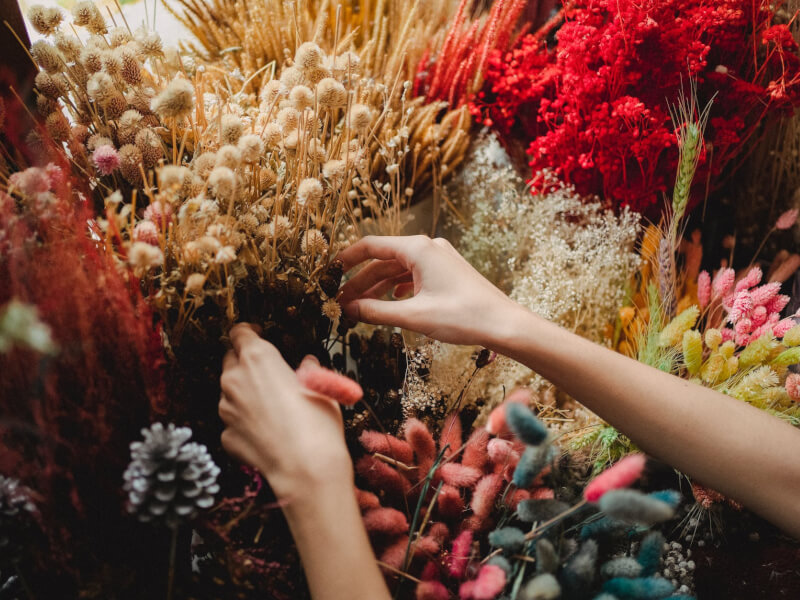 A woman flower arranging in a floristry class.