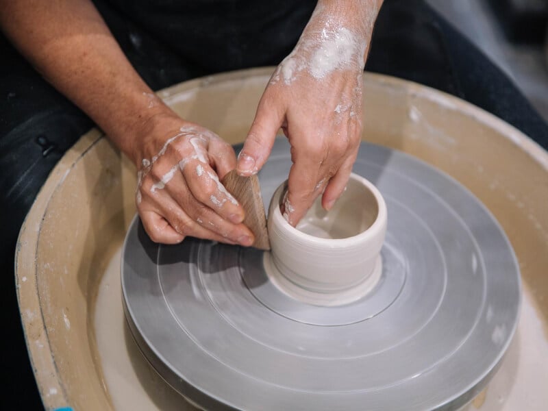 Close up on hands working clay on a potter's wheel