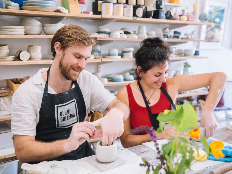 A man and a woman handbuild ceramics at a couples pottery class.