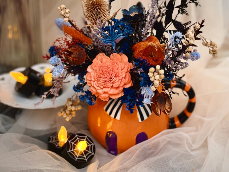 A Halloween floral arrangement in a pumpkin