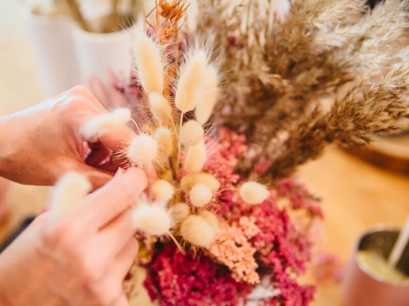 Hands arranging dried flowers