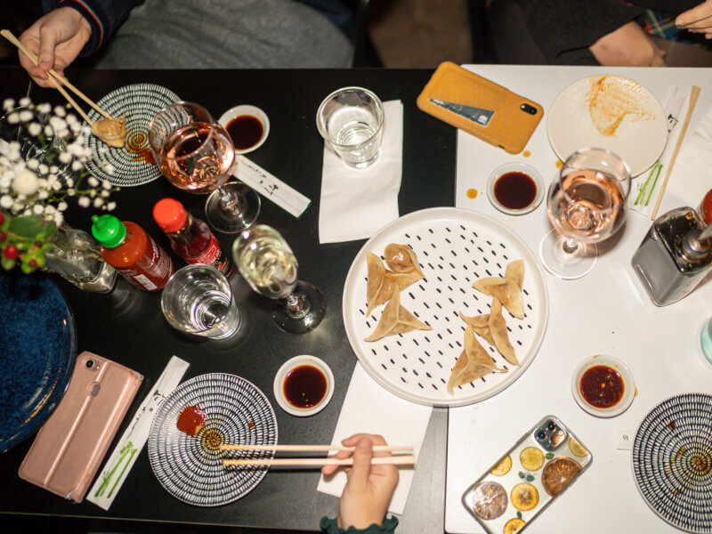 Aerial shot of people eating a variety of Asian fusion dishes