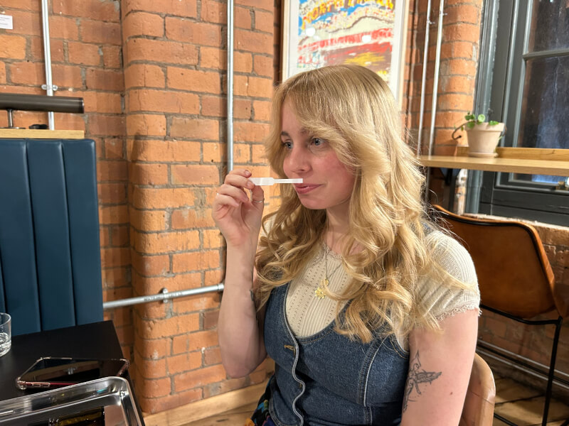 Woman trying out scents in a perfume making class.