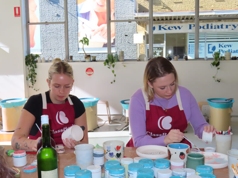 Two people painting ceramics