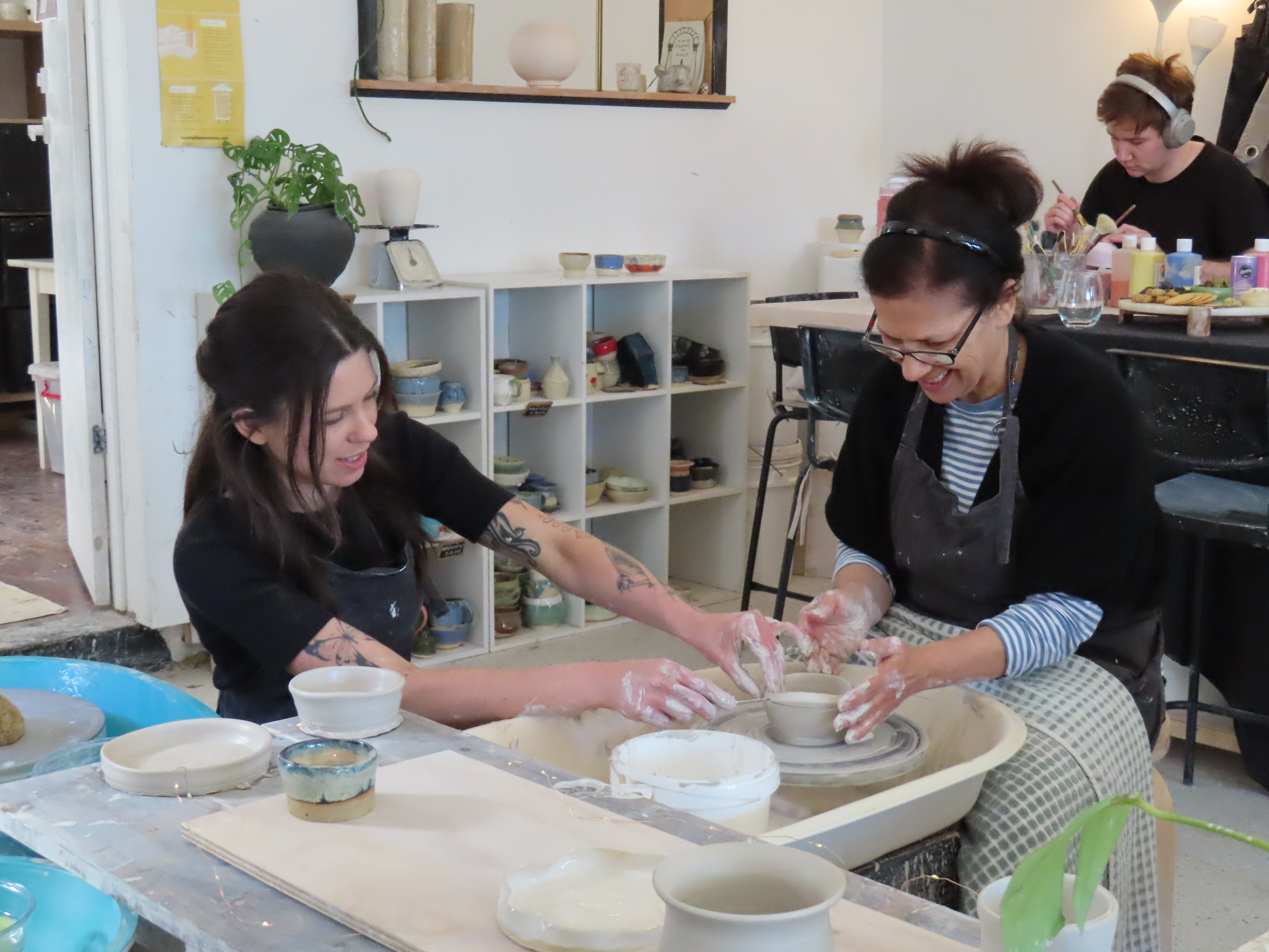 A student and teacher at a pottery class