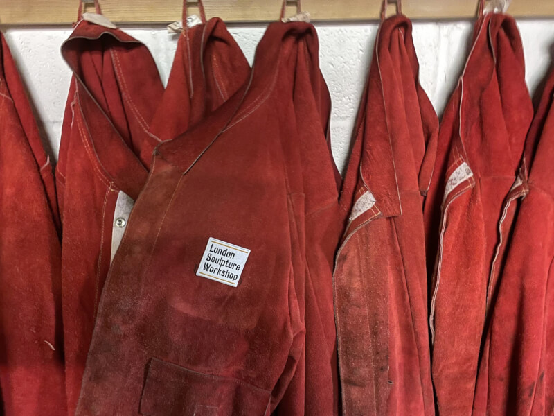 Red jackets handing up with London Sculpture Workshop tag.