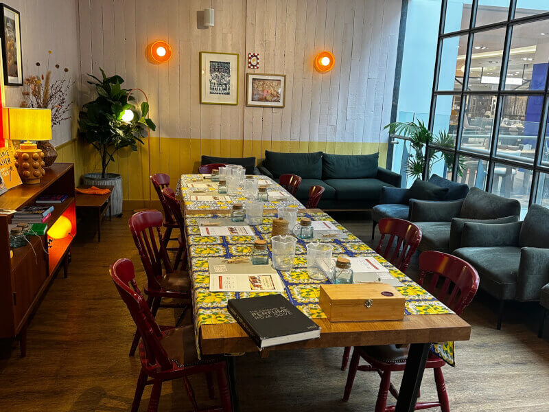 A large room with a table in the centre, set up for a candle making class