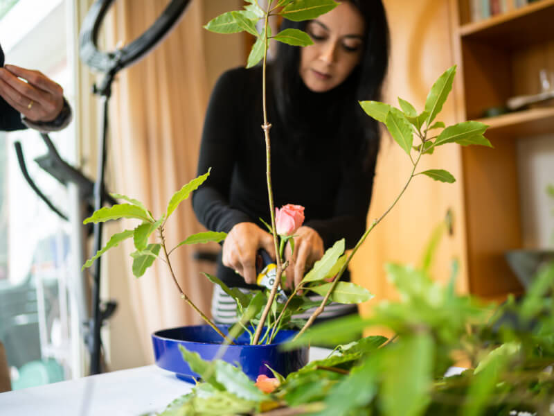 A person working through different green foliage in a floristry class.