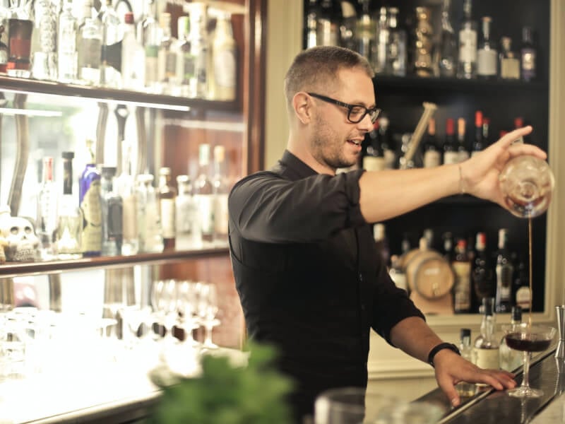 Man pouring spirits into a cocktail glass