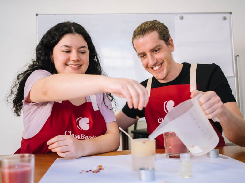 Two people making soy candles at a Christmas craft class