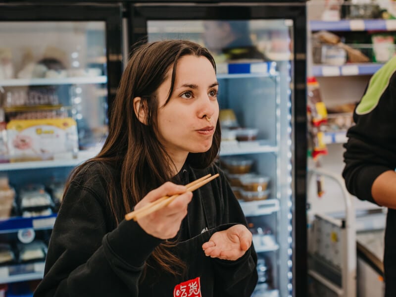 Woman eating with chopsticks at a cooking class