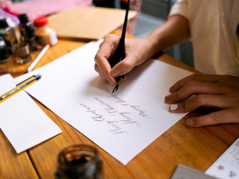 A woman writing in calligraphy
